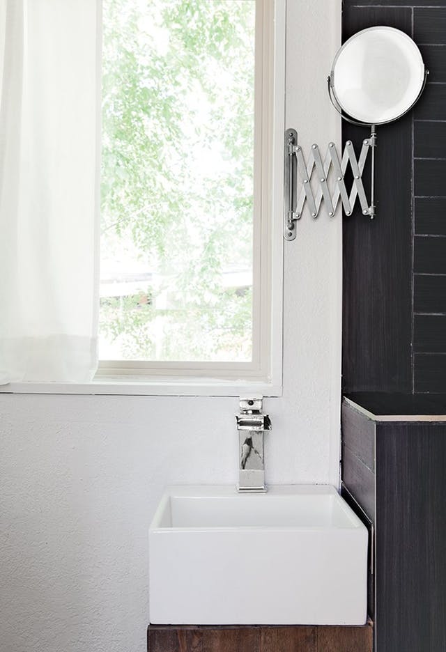 espejo plegable lateral en baño con lavabo pequeño
