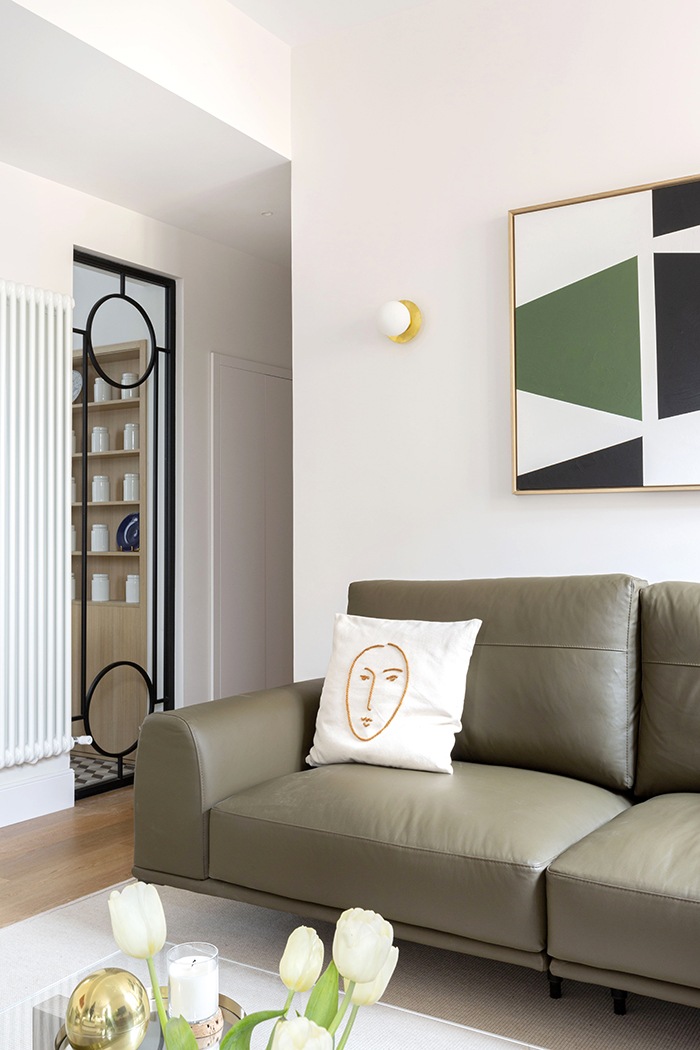 detalle sofa oscuro con cuadro geometrico salon mid century modern