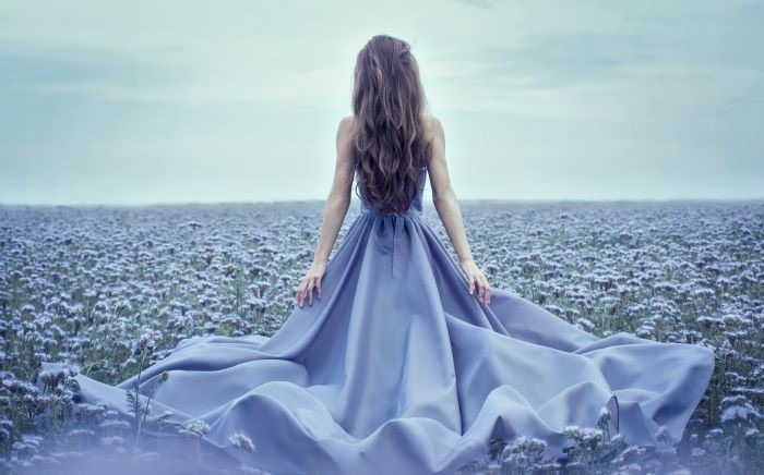 Mujer de espaldas con un vestido formal de color azul de seda