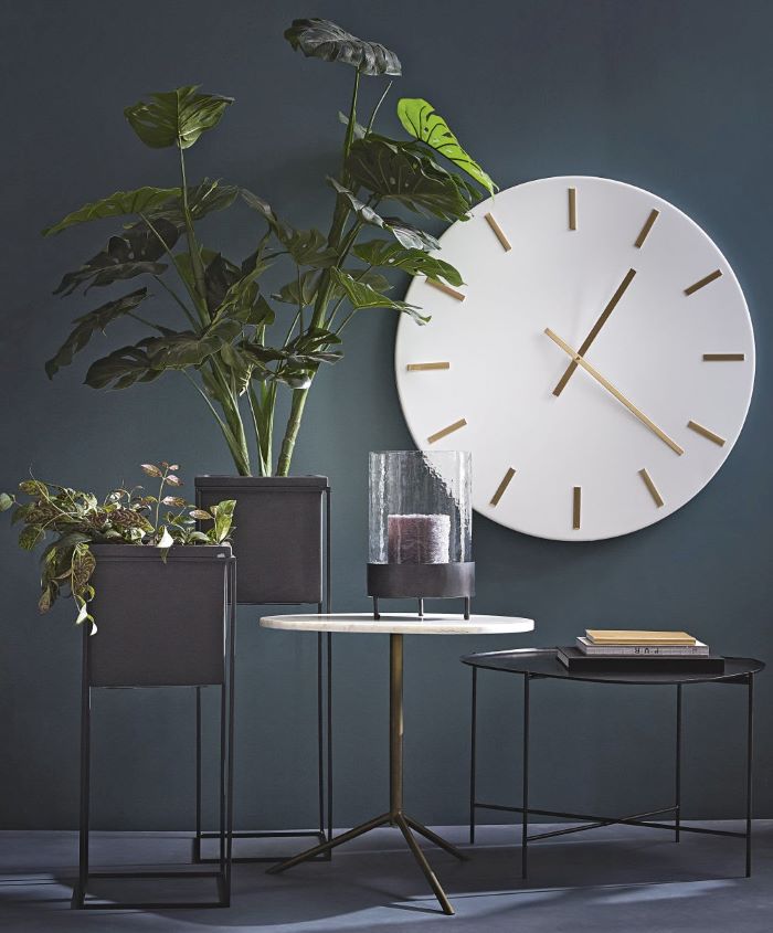 Reloj estilo vintage con decoración de plantas y mesas