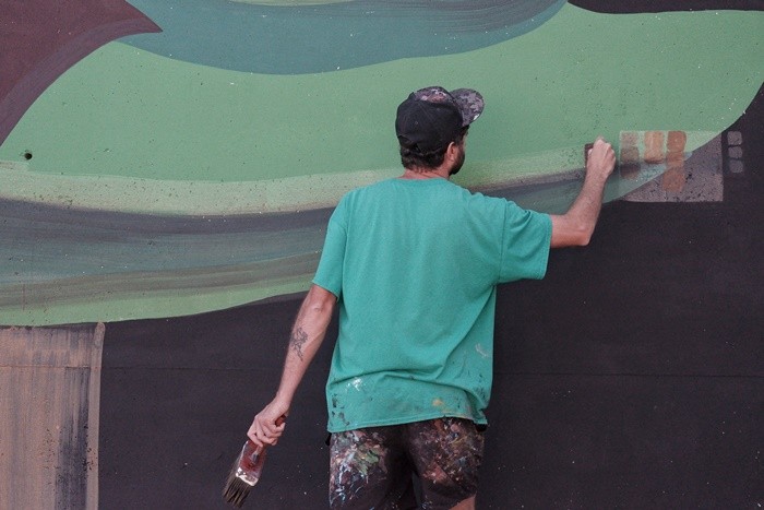 hombre pintando mural verde