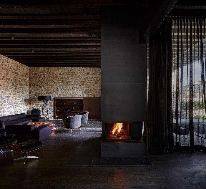 Interior de un proyecto de interiorismo rural con chimenea y materiales de madera