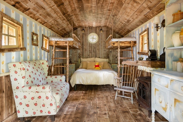 Dormitorio de la casa de winnie the pooh con cama, sillón y otros objetos, Airbnb