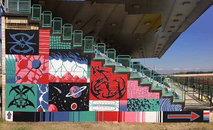 Fachada lateral de unas gradas de futbol con un mural