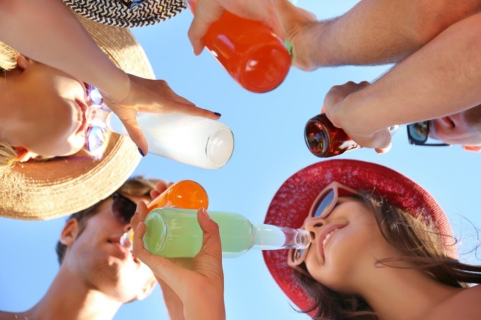 grupo de amigos tomando una bebida en formato vidrio