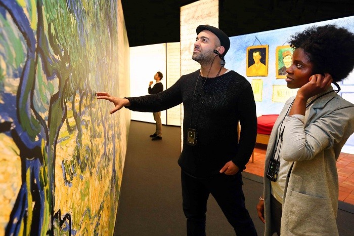hombre tocando una pintura de la exposición Meet Vincent van Gogh