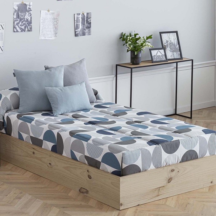 Dormitorio con cama con un edredón ajustable de color azul