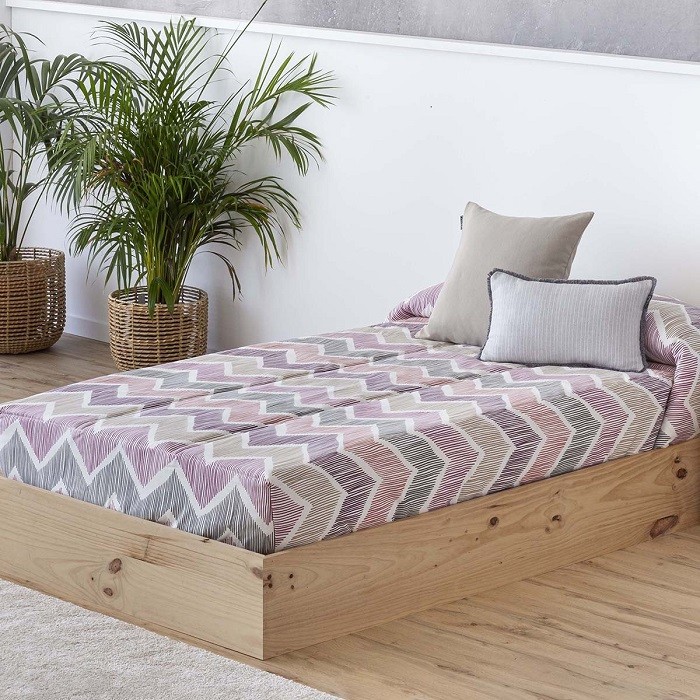 dormitorio con una cama con edredón ajustable