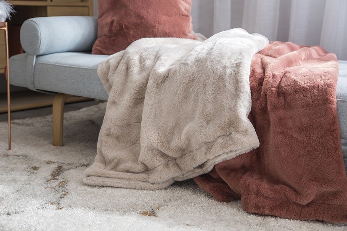 mantas de terciopelo sobre un sofá y alfombra en el suelo