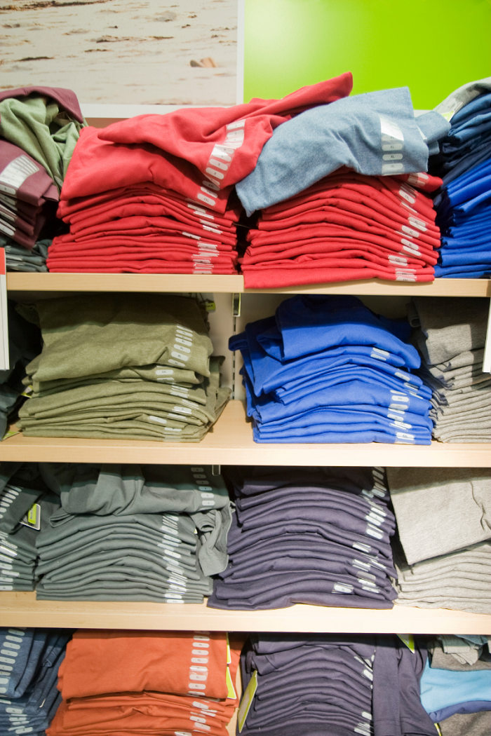 varias camisetas de diferentes colores en una estantería