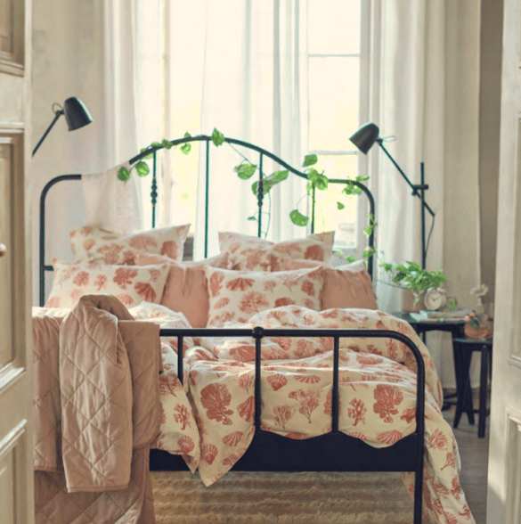 cama con funda nordica y decorada con liana artificial de plantas