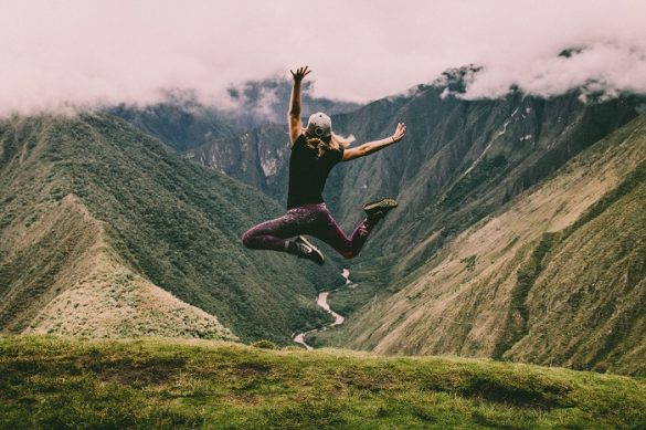 Mujer sola saltando entre las montañas