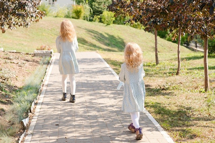 dos niñas paseando por un parque con leotardos y vestido de primavera