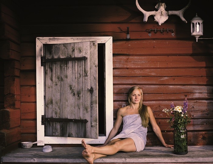 mujer sentada en la entrada a una sauna