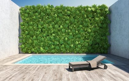 zona de piscina con decoración de un jardín vertical artificial en una pared