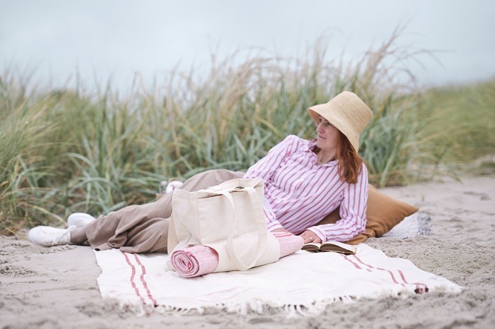 mujer en la naturaleza con bolsa y alfombra de Ikea