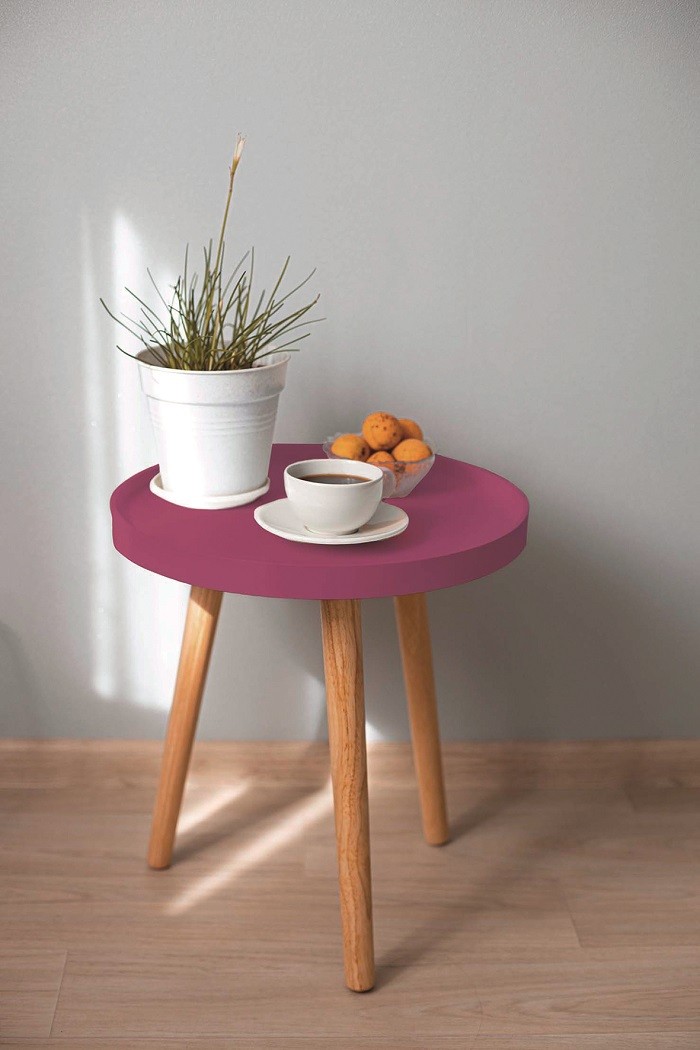 mesa auxiliar rosa con las patas de madera