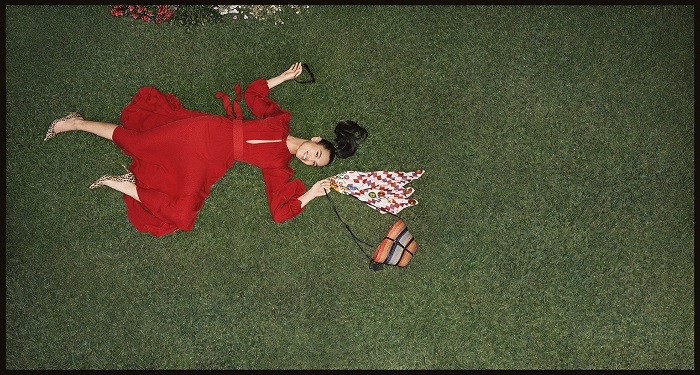 modelo con vestido rojo tumbada en el cesped