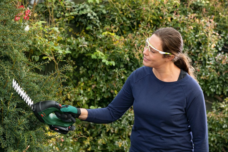 mujer cuidando el jardín con herramientas Bosch