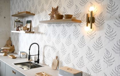 cocina con una pared decorada con papel pintado en motivos de hojas