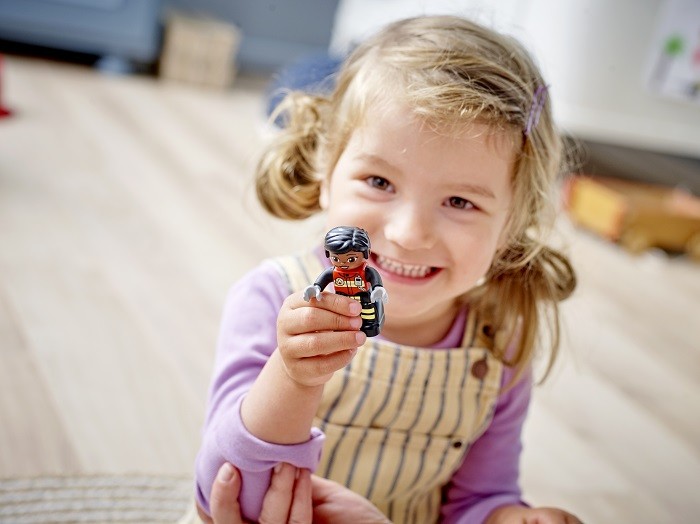niña sujetando un muñeco LEGO