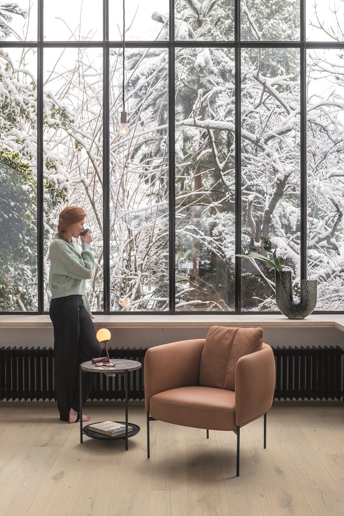 mujer tomando café en el interior de su casa en invierno