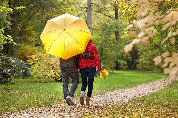 pareja bajo un paraguas amarillo