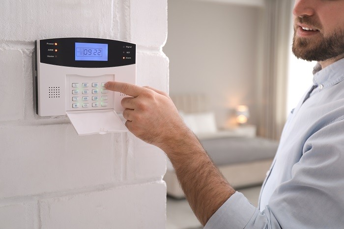 Hombre configurando el sistema de alarma de seguridad en casa
