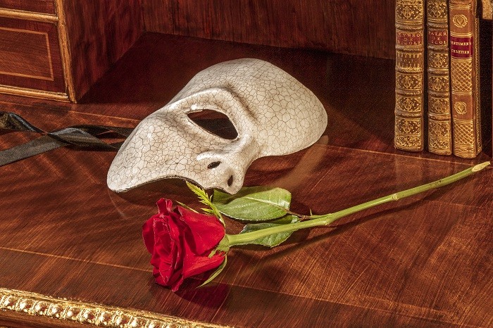 una máscara y una rosa en el escritorio del palacio Garnier