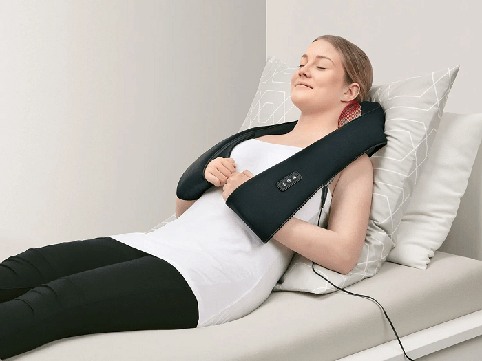 mujer tumbada con un aparato de masaje de Lidl