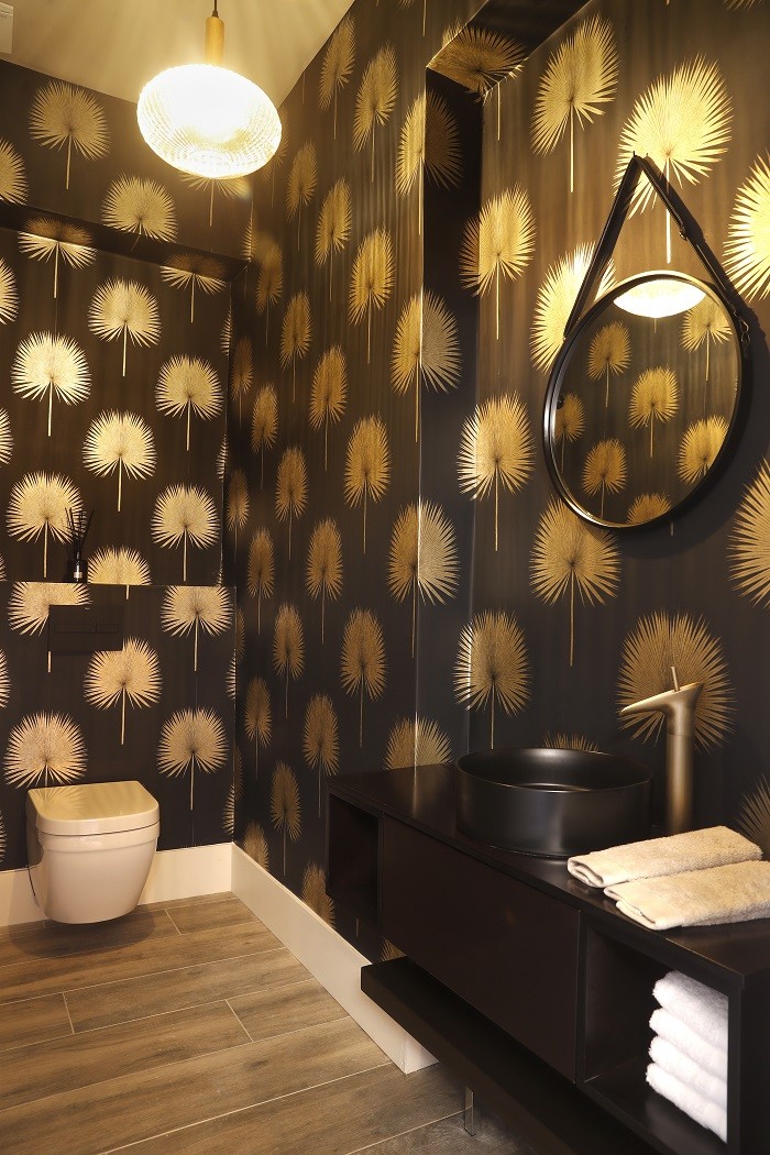 cuarto de baño con decoración con motivos negros y dorados