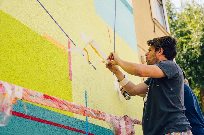 artista Kenor pintando arte urbano en la estación