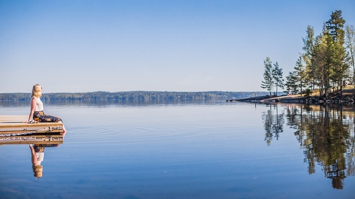 mujer sentada al lado de un lago de Finlandia