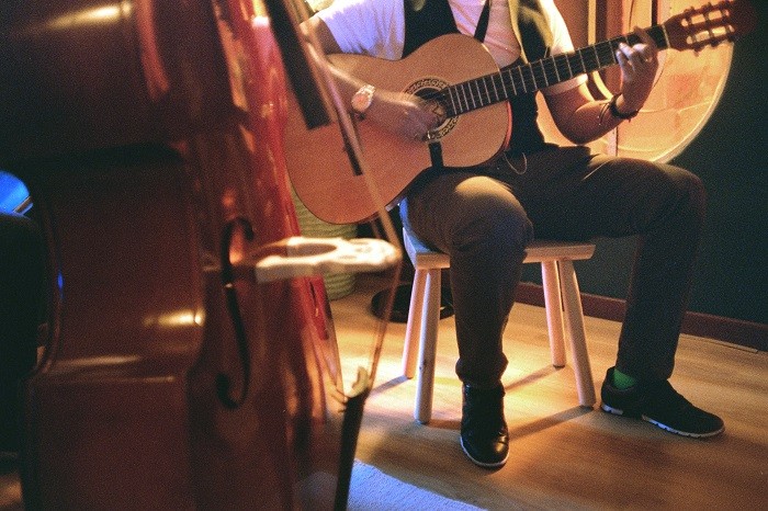músico tocando la guitarra sentado en un taburete de ikea