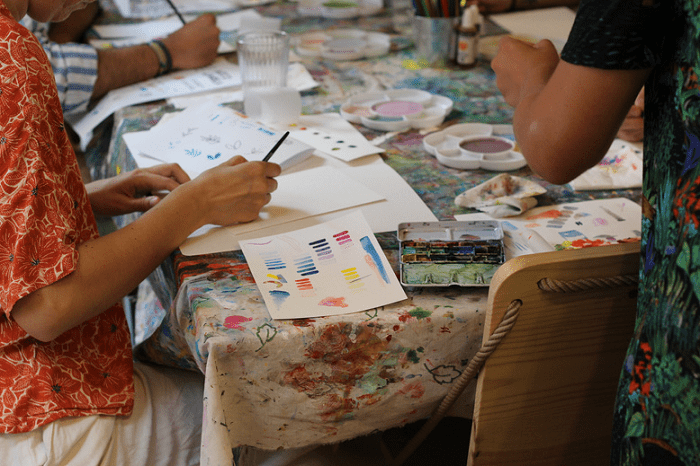 Mesa con personas pintando en un taller