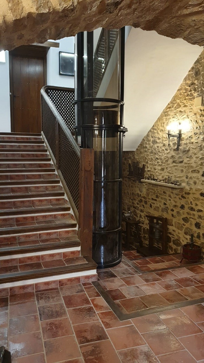 Interior de una casa rústica con ascensor pequeño circular