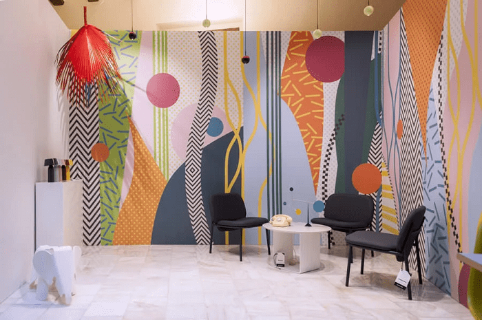 Espacio de un evento con mesa y sillas con pared colorida moderna