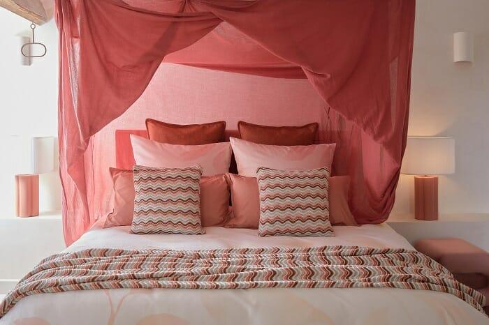 Dormitorio con cama con bastantes cojines coloridos