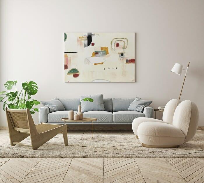 Salón con sofá azul y un cuadro en la pared abstracto y minimalista