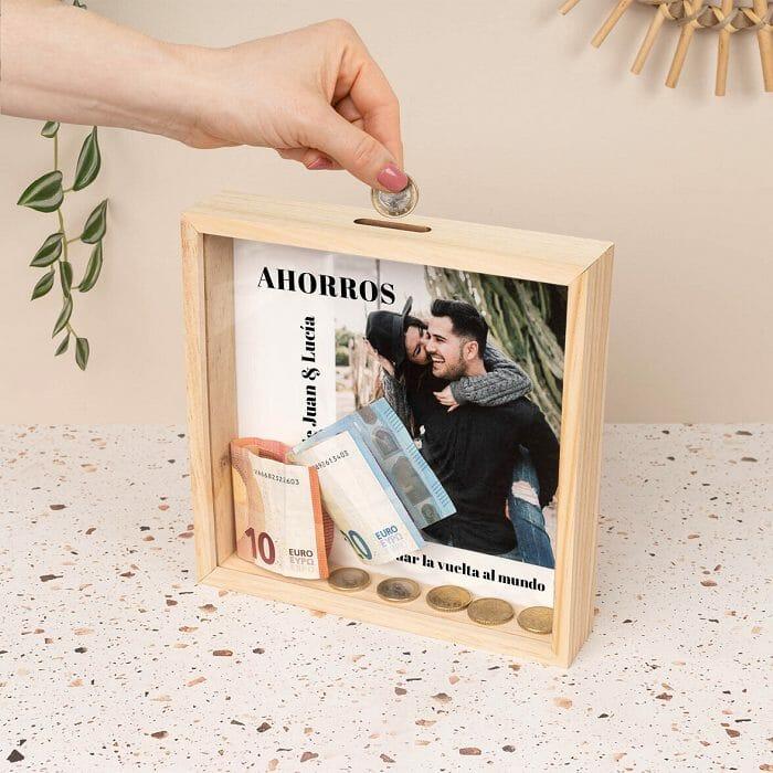 Hucha de madera personalizada con una fotografía de una pareja encima de una mesilla