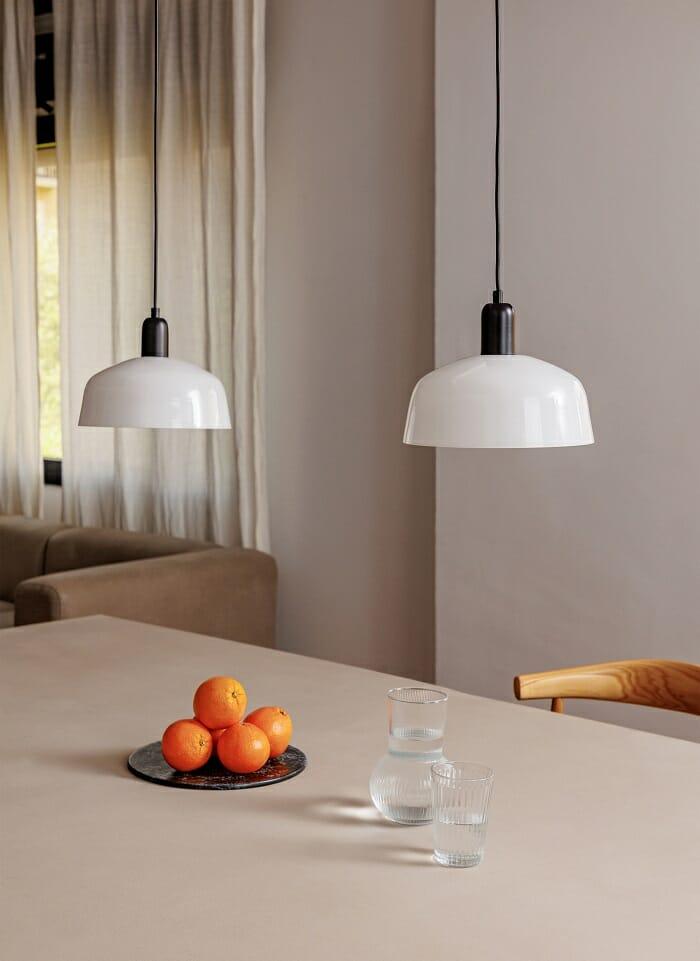 dos lámparas blancas de techo encima de la mesa de la cocina