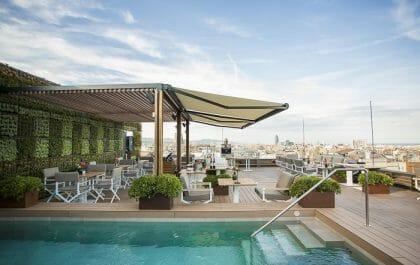Terraza en la azotea de un hotel de Barcelona con piscina y sombrilla