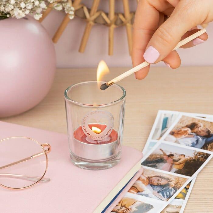mano encendiendo con una cerilla una vela aromática personalizada