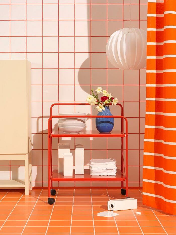 Mesa naranja con baldas y ruedas de la colección Nytillverkad de Ikea