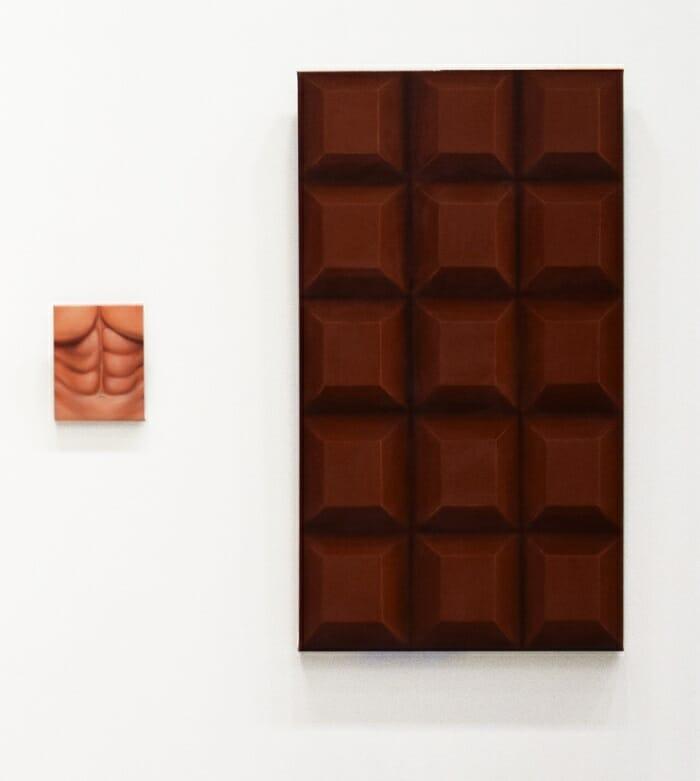 Obra de arte tableta de chocolate con el torso de un hombre al lado Feria Internacional de Arte Contemporáneo en Barcelona