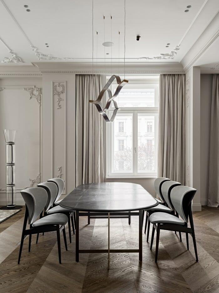 Mesa de comedor con sillas de diseño y lámpara colgante desde el techo
