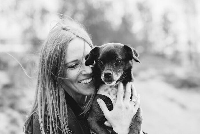 Foto en blanco y negro de una mujer con su mascota cachorro