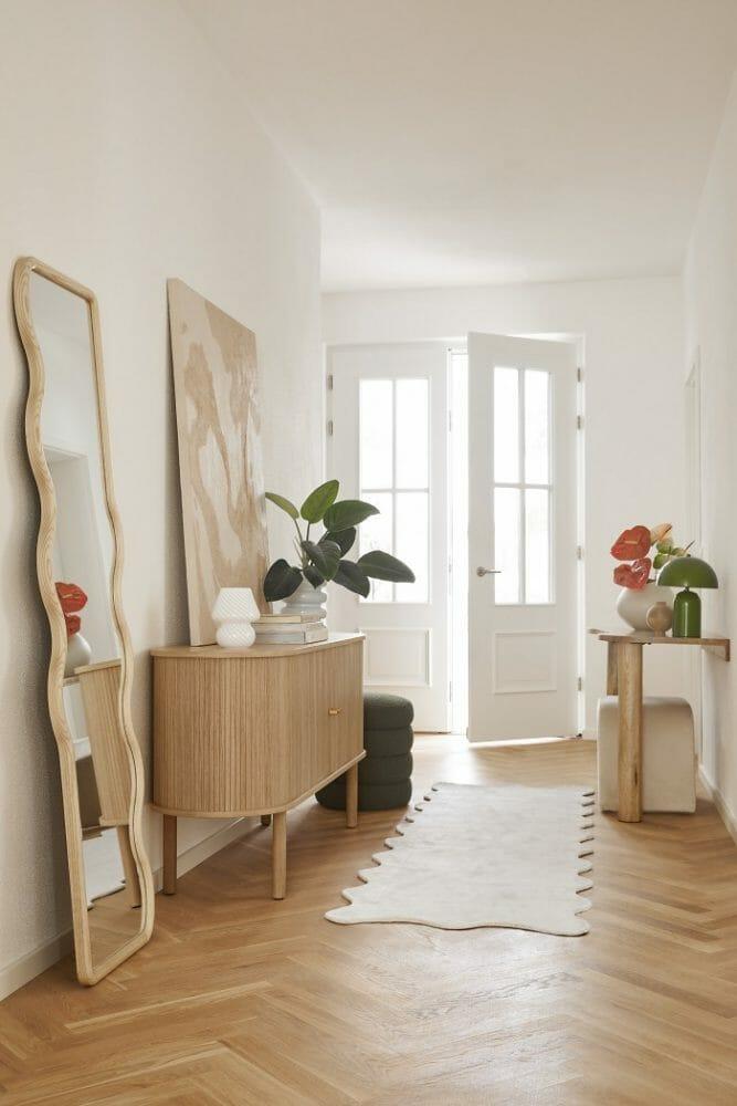 Entrada hall con una decoración con pared en blanco y muebles en madera