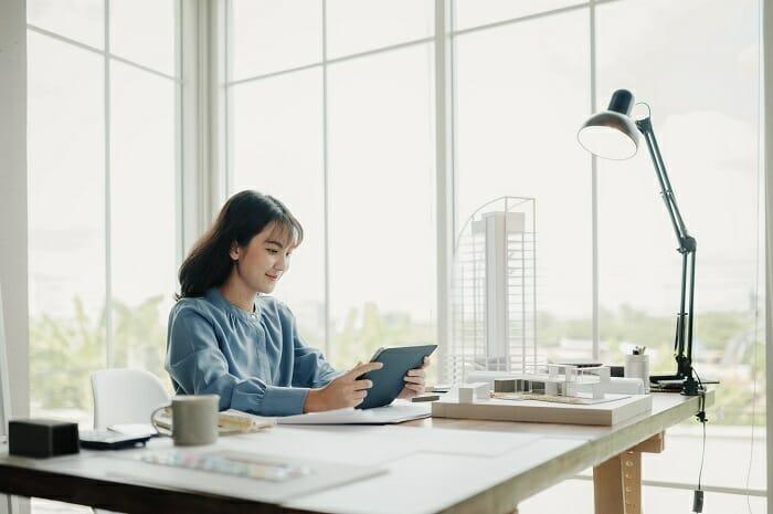 Mujer arquitecta estudiando con su tablet en su despacho un máster BIM online