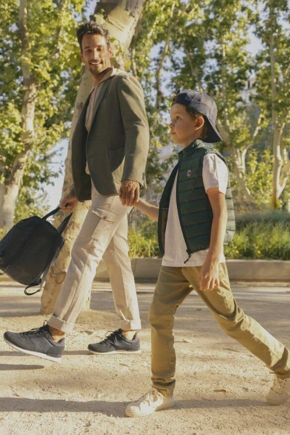 Padre con su hijo dados de la mano y caminando por la calle con un estilo de ropa de la marca Scotta